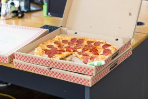 Delicious pepperoni pizza in an open box on a desk, perfect for a quick meal.