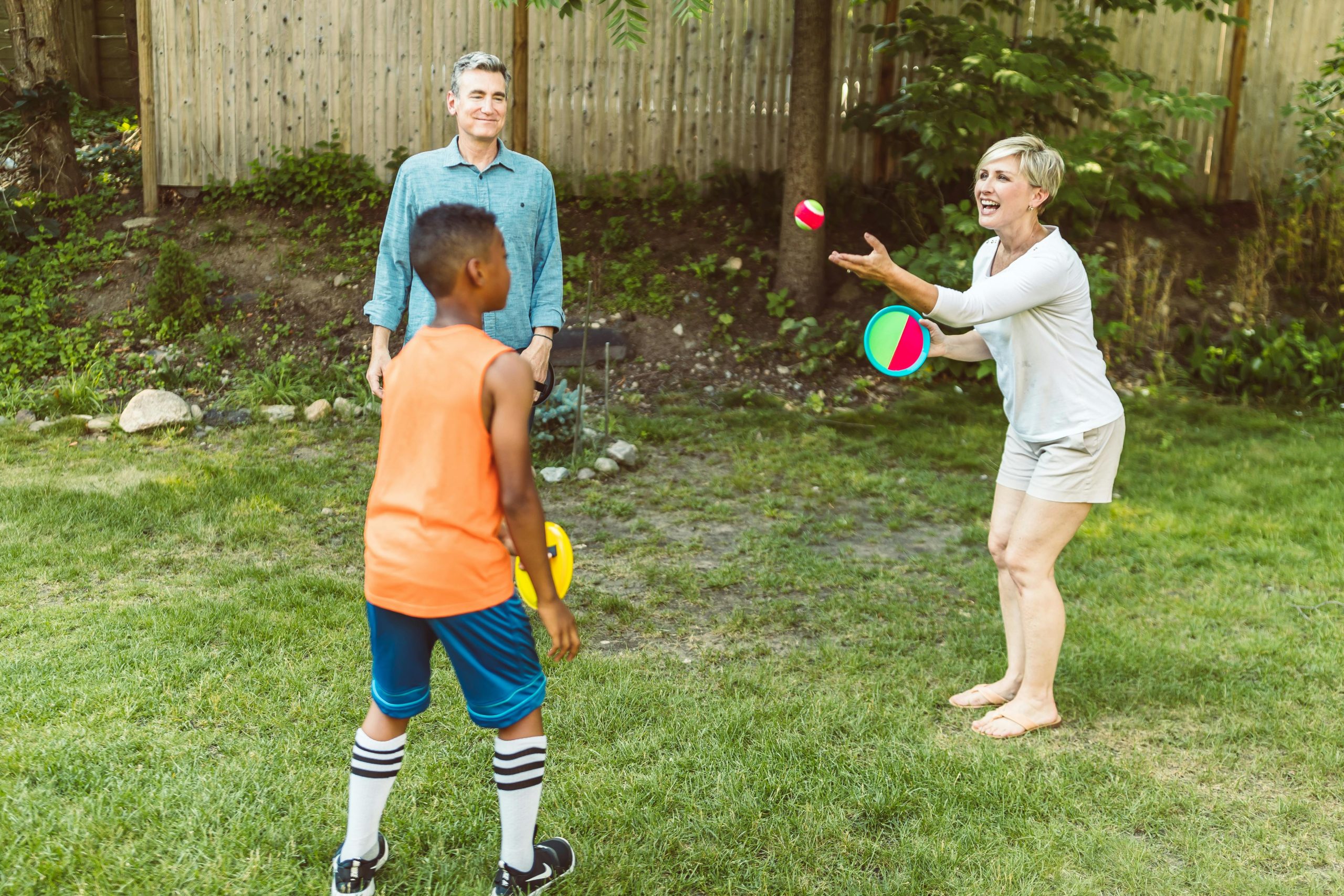 A cheerful family enjoying outdoor playtime in a sunny backyard, fostering family bonding.